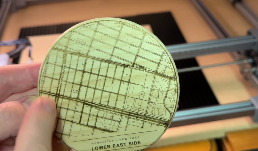 A finished light wood coaster engraved with a detailed city street map, clearly readable across the whole surface