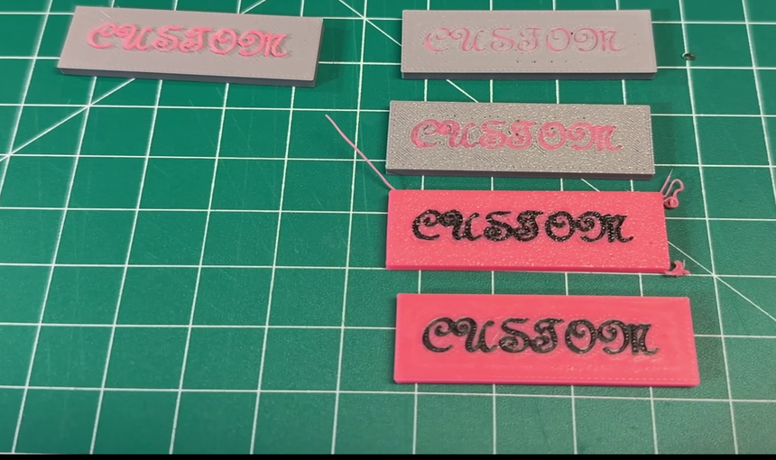 Four printed test plates on a cutting mat, the two printed face down noticeably paler and blurrier than the two printed face up